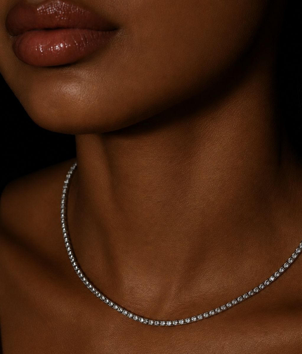 Close-up of a person wearing a delicate diamond moissanite white gold silver necklace against a dark background