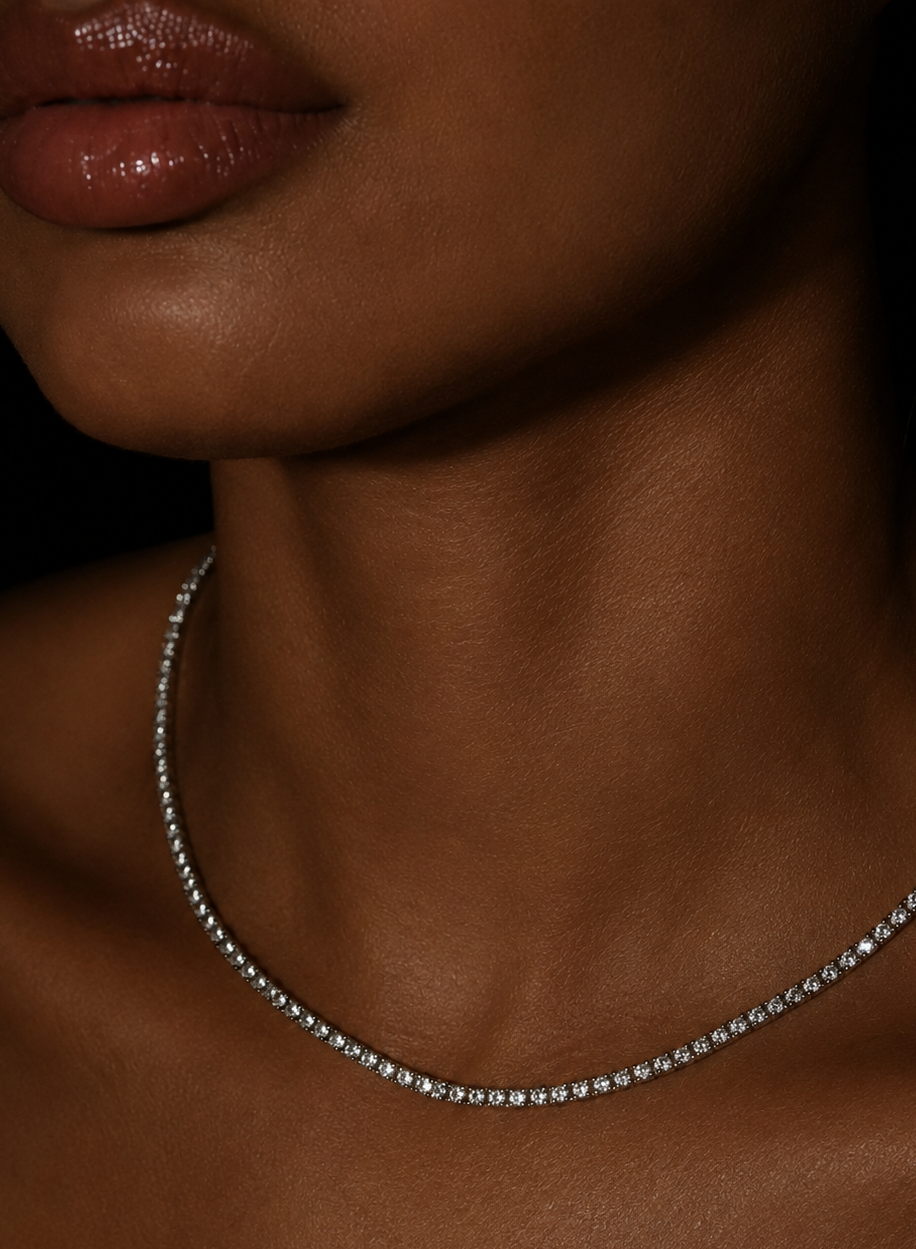 Close-up of a tennis diamond moissanite necklace on a person's neck with a dark background